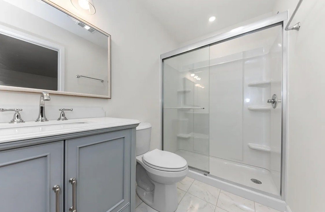 Bathroom with gray vanity and glass shower