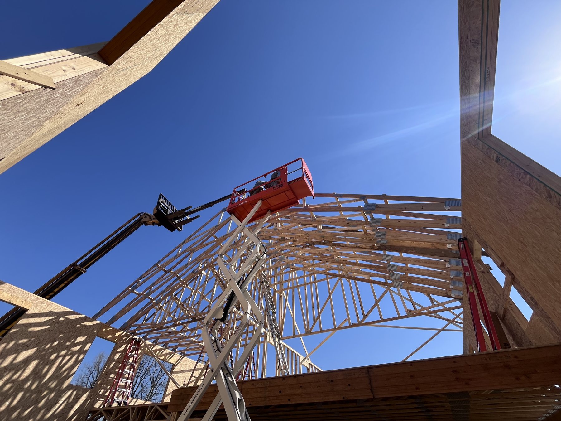 Roof trusses being set with a lift